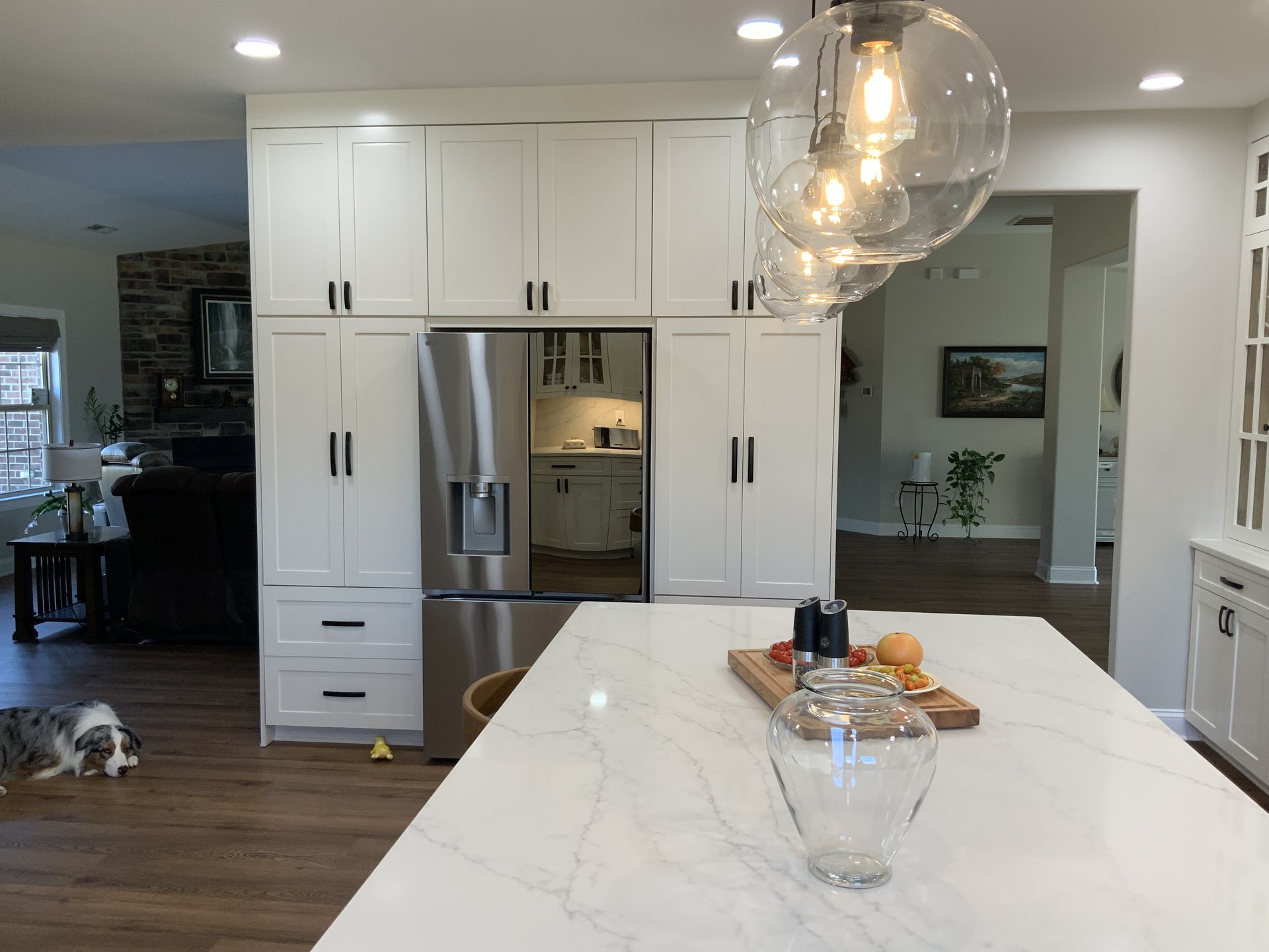 Floor-to-ceiling white shaker kitchen with quartz island